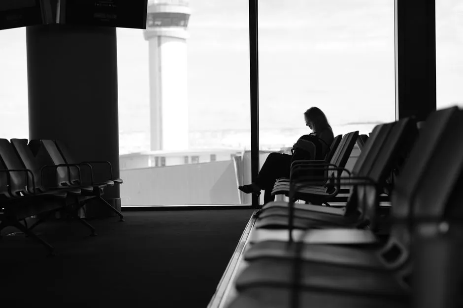 Traveler seated in an airport lounge waiting area, illustrative photo